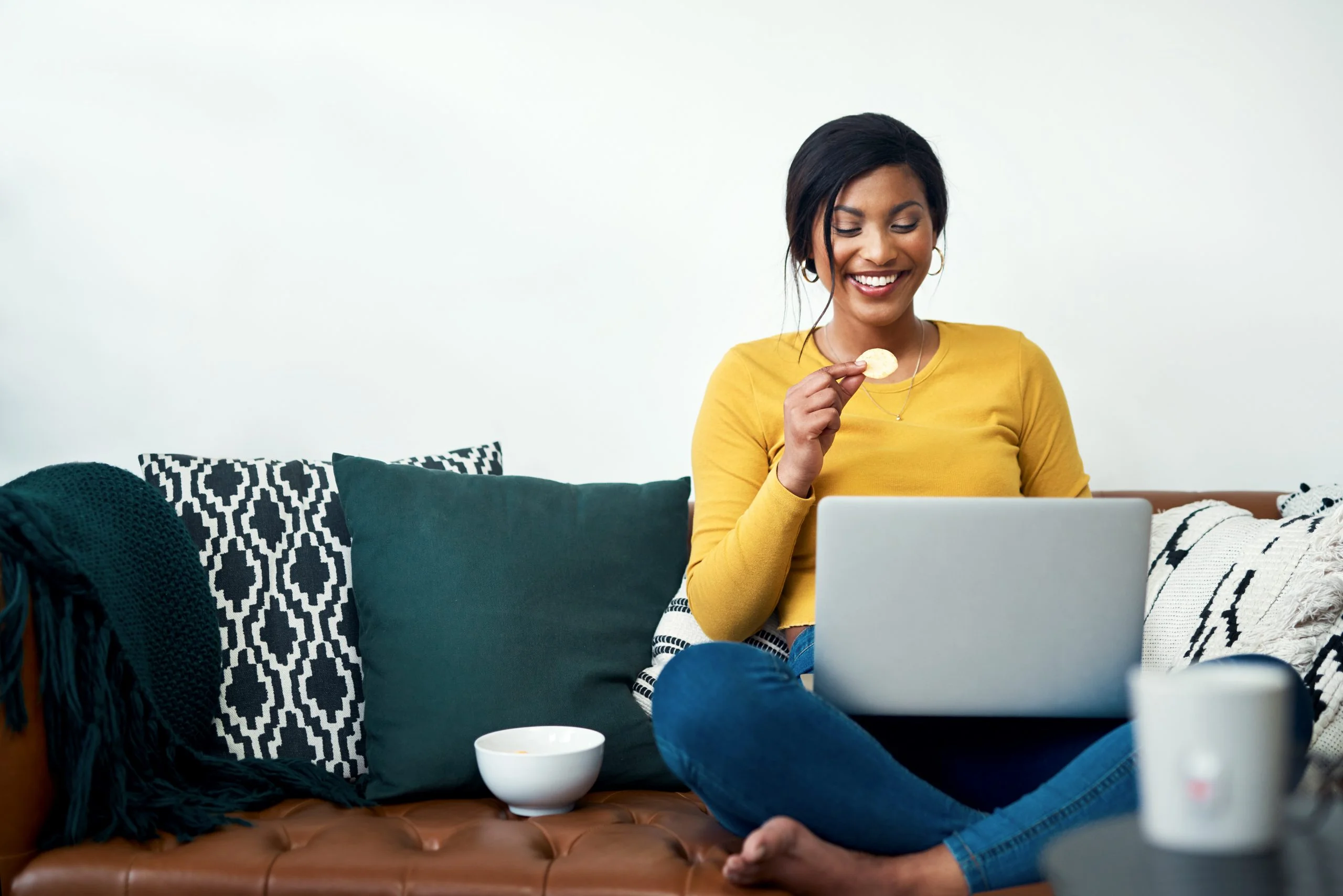 A woman sitting on the ground with her laptop.