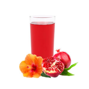A glass of juice with some fruit on the side