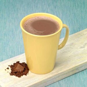 A yellow cup of coffee and some chocolate powder.