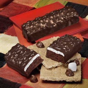 A chocolate bar with white frosting and nuts on top.